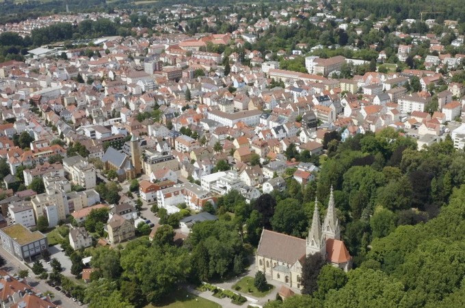 Luftaufnahme einer Stadt mit dicht bebauten H&auml;usern und einer markanten Kirche, umgeben von gr&uuml;nen B&auml;umen und Parks., &copy; Stadt G&ouml;ppingen