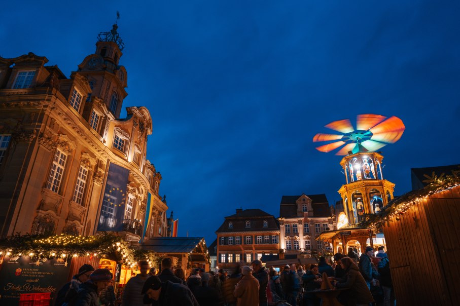 Weihnachtsmarkt in Schwäbisch Hall bei Nacht, mit festlich beleuchteten Ständen mit dem Rathaus und einer Weihnachtspyramide im Vordergrund., © Michael Kuehneisen Weihnachtsmarkt in Schwäbisch Hall bei Nacht, mit festlich beleuchteten Ständen mit dem Rathaus und einer Weihnachtspyramide im Vordergrund., © Michael Kuehneisen