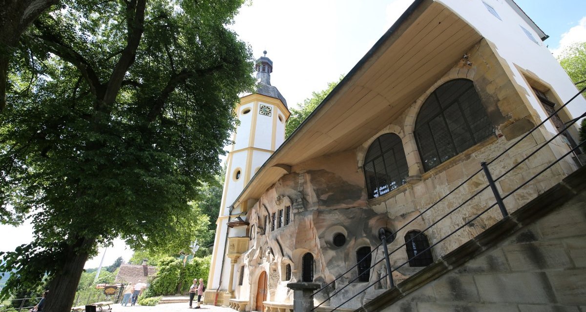 Felsenkapelle St. Salvator. Im Hintergrund stehen zwei Wanderer. Zwei Personen laufen aus dem Bild. Vor der Kapelle steht ein großer grüner Baum., © Foto: Walter Laible Felsenkapelle St. Salvator. Im Hintergrund stehen zwei Wanderer. Zwei Personen laufen aus dem Bild. Vor der Kapelle steht ein großer grüner Baum., © Foto: Walter Laible