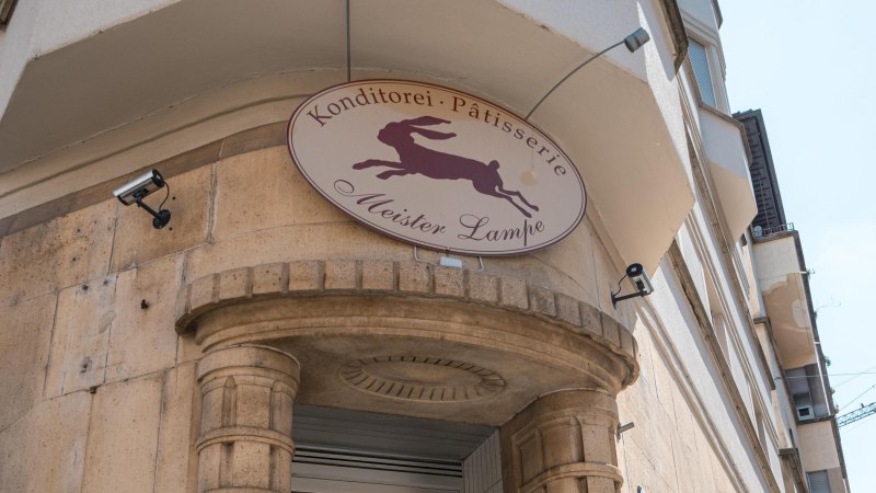 Schild der Konditorei 'Meister Lampe' mit springendem Hasen, an einer Geb&auml;udefassade montiert., &copy; SMG, Sarah Schmid