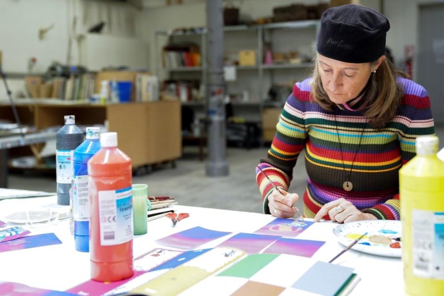 Frau in gestreiftem Pullover malt konzentriert in einem Kunstworkshop. Auf dem Tisch stehen bunte Farbtuben und Pinsel., © Kunstschule Labyrinth Frau in gestreiftem Pullover malt konzentriert in einem Kunstworkshop. Auf dem Tisch stehen bunte Farbtuben und Pinsel., © Kunstschule Labyrinth