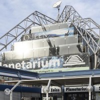 Das Carl-Zeiss Planetarium Stuttgart mit moderner Glas- und Stahlarchitektur, Werbebanner und klarem Himmel im Hintergrund., &copy; Stuttgart-Marketing GmbH, Sarah Schmid