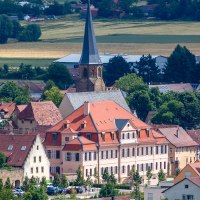 Panoramablick auf Bönnigheim mit einer Kirche im Zentrum, umgeben von roten Dächern und Fachwerkhäusern, eingebettet in eine grüne Landschaft., © Stuttgart-Marketing GmbH
