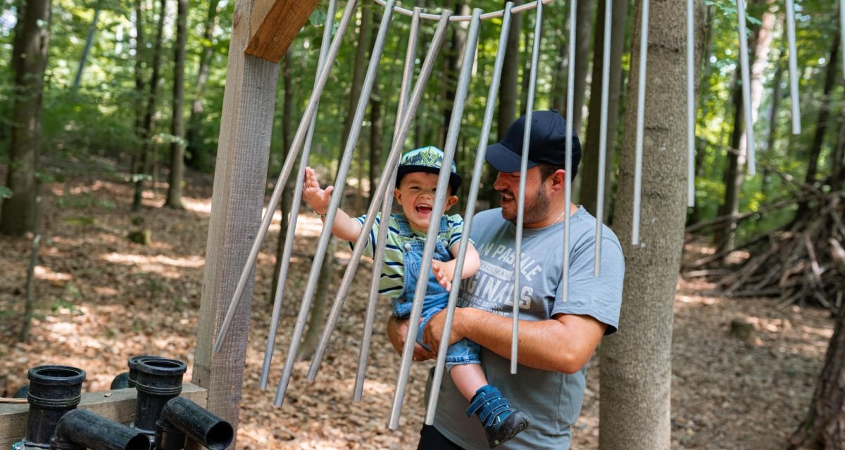 Ein Mann und ein Kind spielen fr&ouml;hlich mit einem gro&szlig;en Xylophon aus Metallst&auml;ben im Wald., &copy; Stadtmarketing Weil der Stadt