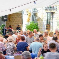Geselliges Beisammensein im Freien bei Weingut Zai&szlig;. Menschen genie&szlig;en Essen und Getr&auml;nke unter einem Sonnensegel., &copy; Weingut Zai&szlig;
