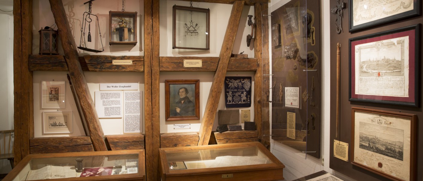 Ein Ausstellungsraum im Stadtmuseum zeigt historische Dokumente, Bilder und Werkzeuge. Holzbalken und Vitrinen pr&auml;gen das Ambiente., &copy; Stadtverwaltung Weil der Stadt