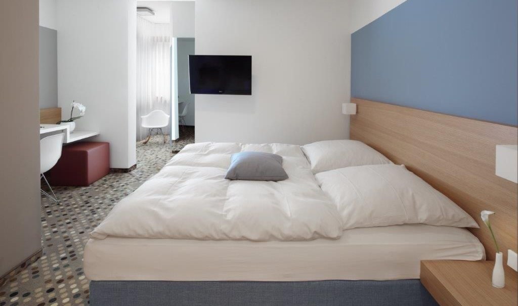 Modernes Doppelzimmer mit großem Bett, Schreibtisch, Flachbildfernseher und stilvollem Teppichboden., © Hotel Waldhorn Modernes Doppelzimmer mit großem Bett, Schreibtisch, Flachbildfernseher und stilvollem Teppichboden., © Hotel Waldhorn