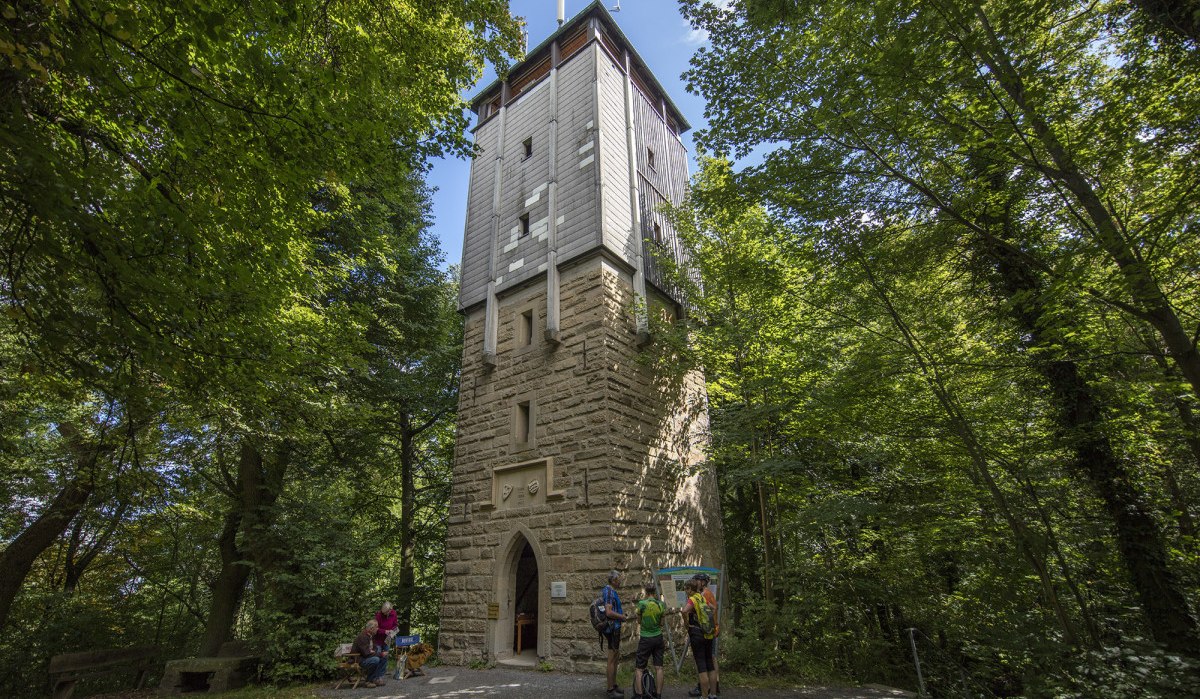 Der Wunnensteinturm steht im Wald, umgeben von Bäumen. Vor dem Turm sind mehrere Personen zu sehen, die den Turm betrachten., © Stuttgart Marketing GmbH Der Wunnensteinturm steht im Wald, umgeben von Bäumen. Vor dem Turm sind mehrere Personen zu sehen, die den Turm betrachten., © Stuttgart Marketing GmbH