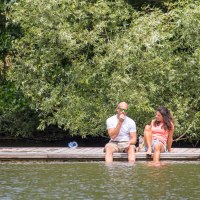 Zwei Personen sitzen auf einem Steg am Wasser, umgeben von üppigem Grün. Sie genießen die Natur im Naherholungsgebiet Bürgerseen Kirchheim unter Teck., © Stadt Kirchheim unter Teck