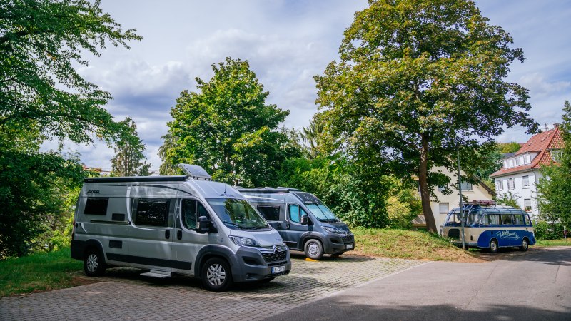 Wohnmobilstellplatz mit mehreren geparkten Wohnmobilen, umgeben von Bäumen und einem Haus im Hintergrund., © Stuttgart-Marketing GmbH, Thomas Niedermüller Wohnmobilstellplatz mit mehreren geparkten Wohnmobilen, umgeben von Bäumen und einem Haus im Hintergrund., © Stuttgart-Marketing GmbH, Thomas Niedermüller
