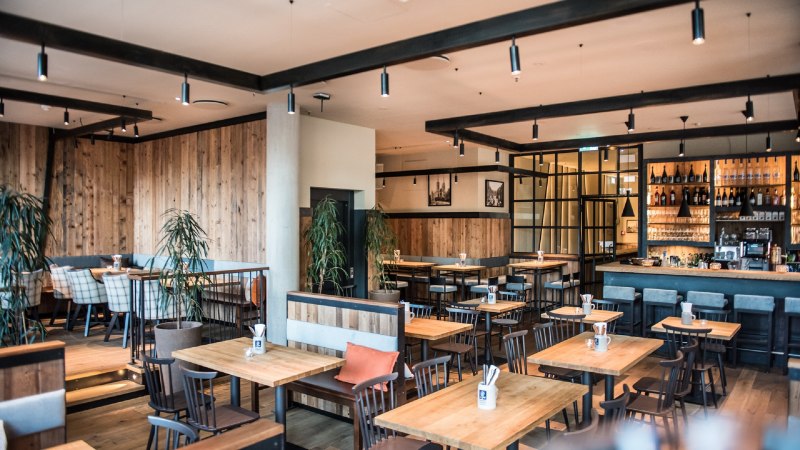 Modernes Brauhaus mit Holzm&ouml;beln, Bar und Pflanzen. Gem&uuml;tliche Atmosph&auml;re mit Holzw&auml;nden und stilvoller Beleuchtung., &copy; Andreas Engelhard - Engelhard Photography