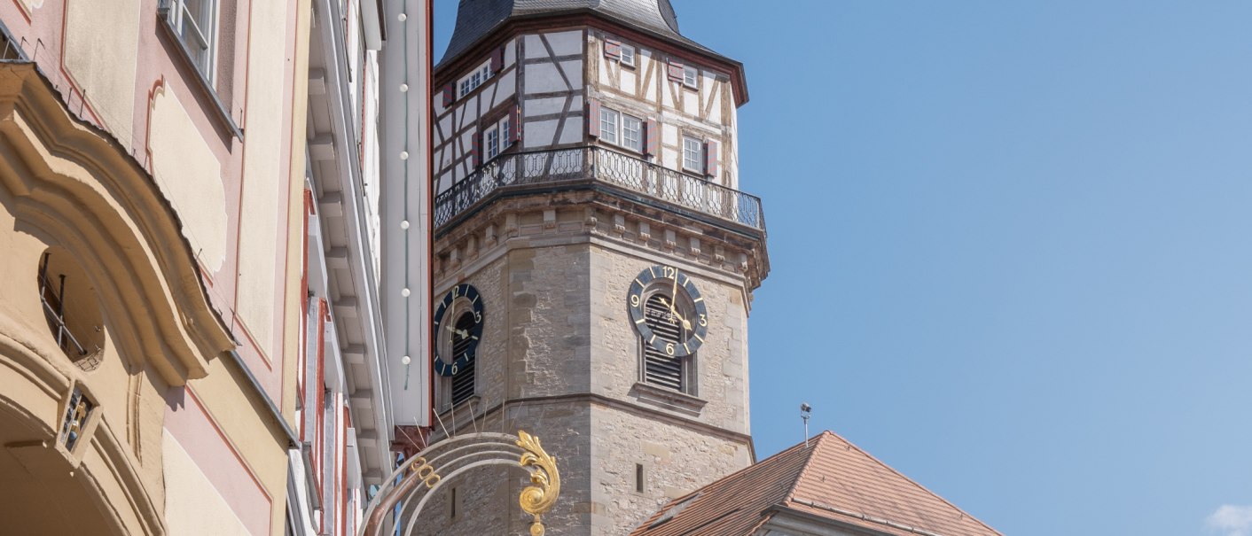 Der Backnanger Stadtturm mit Fachwerk und Uhr ragt zwischen Gebäuden hervor, unter klarem, blauem Himmel., © Stuttgart-Marketing GmbH, Martina Denker Der Backnanger Stadtturm mit Fachwerk und Uhr ragt zwischen Gebäuden hervor, unter klarem, blauem Himmel., © Stuttgart-Marketing GmbH, Martina Denker