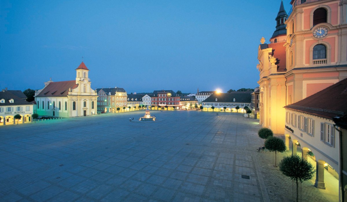 Der Ludwigsburger Marktplatz bei Abenddämmerung, umgeben von beleuchteten historischen Gebäuden und einer Kirche., © Land der 1000 Hügel - Kraichgau-Stromberg Der Ludwigsburger Marktplatz bei Abenddämmerung, umgeben von beleuchteten historischen Gebäuden und einer Kirche., © Land der 1000 Hügel - Kraichgau-Stromberg