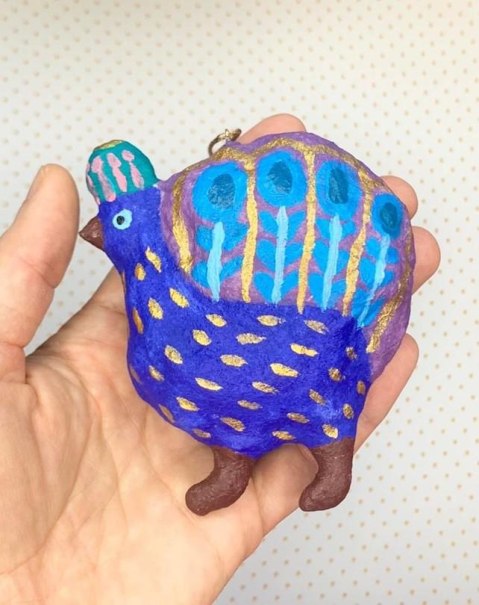 Eine Hand hält ein bunt bemaltes, wolliges Tier mit blauen und goldenen Mustern. Hintergrund ist hell mit Punkten., © Kunstschule Labyrinth