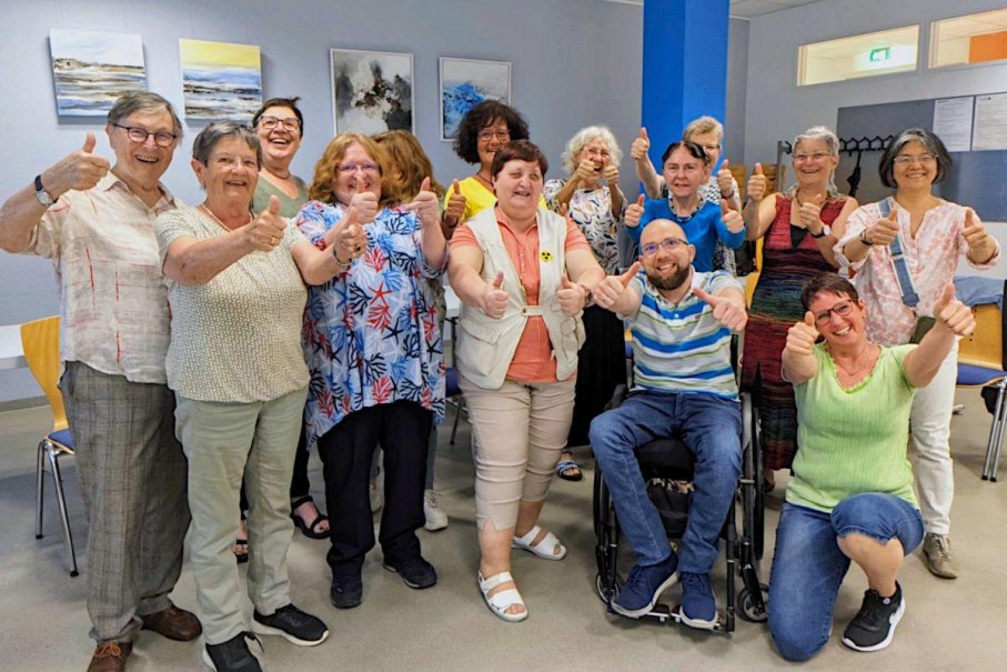 Eine Gruppe von Menschen in einem Raum, die fröhlich Daumen hoch zeigen. Sie stehen und sitzen zusammen, lächelnd, vor einer Wand mit Bildern., © Bürgerengagement und Bürgerhäuser Eine Gruppe von Menschen in einem Raum, die fröhlich Daumen hoch zeigen. Sie stehen und sitzen zusammen, lächelnd, vor einer Wand mit Bildern., © Bürgerengagement und Bürgerhäuser