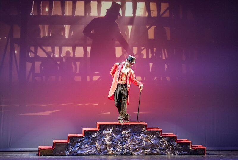 Ein Plakat f&uuml;r die Kinovorf&uuml;hrung von 'The Greatest Showman' mit live getanzten Filmszenen. Ein Mann in rotem Frack h&auml;lt einen Zylinderhut., &copy; Stadthalle Leonberg