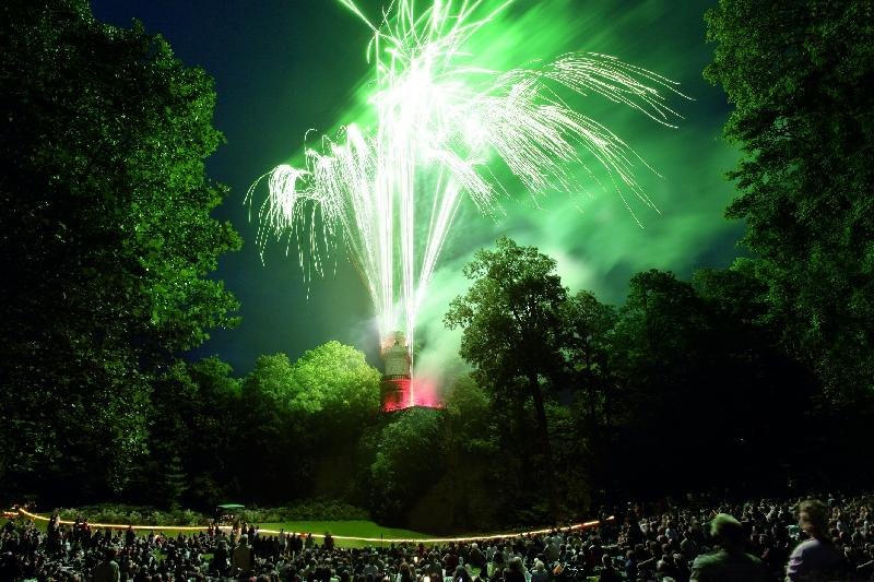 Ein spektakul&auml;res Feuerwerk erleuchtet den Nachthimmel &uuml;ber einem Turm, umgeben von B&auml;umen und einer gro&szlig;en Menschenmenge in einem Park., &copy; copyright: Marc Sansone