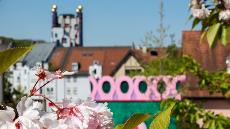 Kirschblüten im Vordergrund, bunte Architektur im Hintergrund in Plochingen, sonniger Tag., © Stuttgart-Marketing GmbH