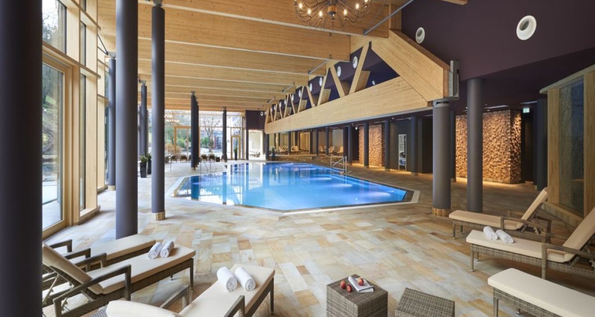 Eleganter Spa-Bereich mit gro&szlig;em Pool, Liegest&uuml;hlen und Holzdecke in der Hotel Therme Bad Teinach. Entspannte Atmosph&auml;re mit nat&uuml;rlichem Licht., &copy; N&ouml;rdlicher Schwarzwald