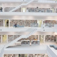 Innenansicht der Stadtbibliothek Stuttgart mit mehreren Etagen, weißen Wänden und Regalen voller Bücher. Menschen bewegen sich auf den Ebenen., © Stuttgart-Marketing GmbH, Sarah Schmid