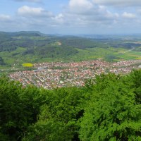 Panoramablick auf eine Stadt mit roten Dächern, umgeben von grünen Hügeln und Wäldern unter einem bewölkten Himmel., © Landkreis Göppingen Panoramablick auf eine Stadt mit roten Dächern, umgeben von grünen Hügeln und Wäldern unter einem bewölkten Himmel., © Landkreis Göppingen