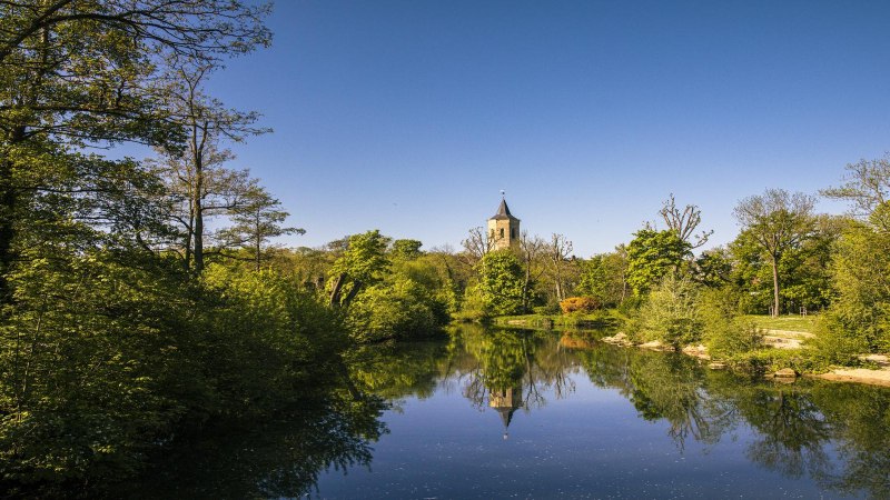 Fluss mit klarem Wasser, umgeben von üppigem Grün. Ein Kirchturm ragt im Hintergrund in den blauen Himmel., © SMG, Sarah Schmid
