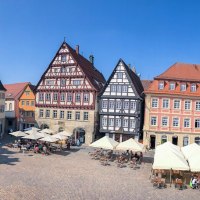 Historischer Marktplatz mit Fachwerkhäusern, Rathaus und Johanniskirche unter blauem Himmel. Menschen sitzen in Cafés und genießen die Atmosphäre., © Für die Bildrechte: Amt für Medien und Kommunikation Schwäbisch Gmünd