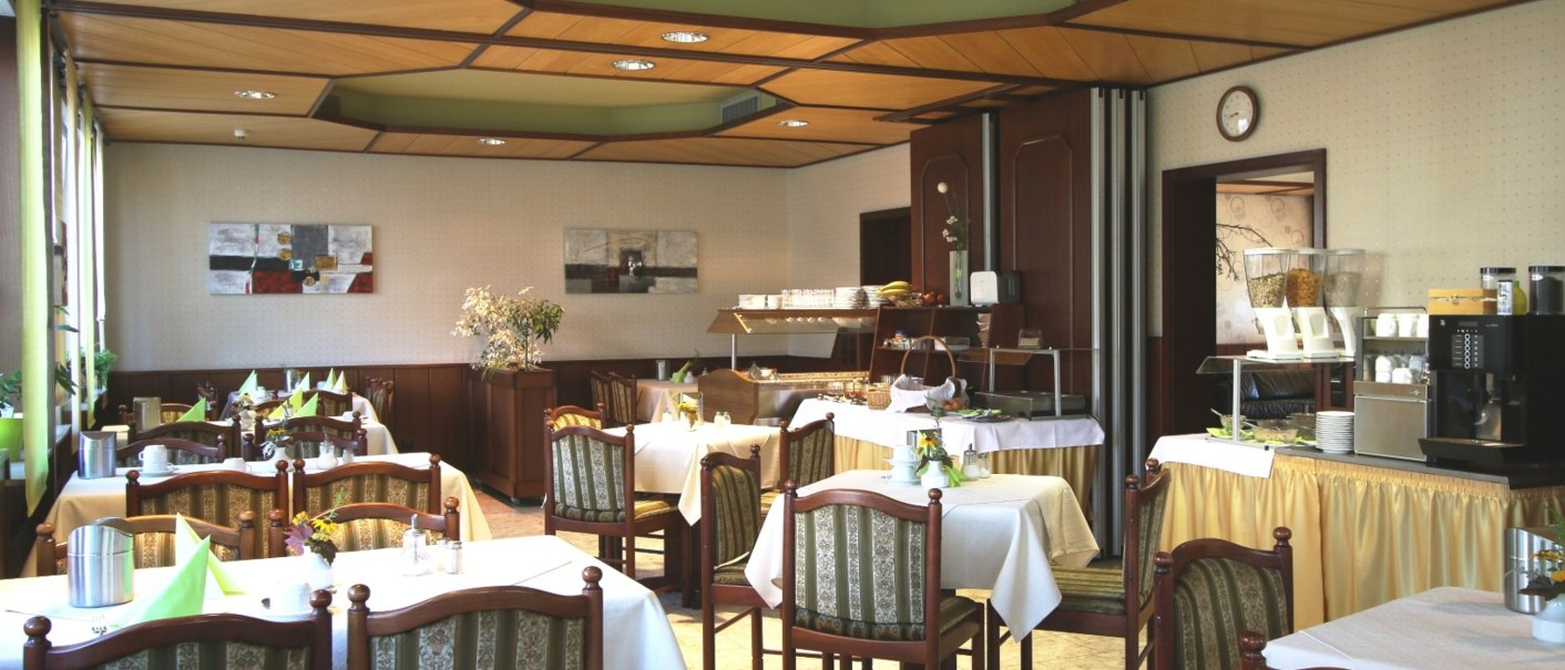 Ein gemütlicher Frühstücksraum mit gedeckten Tischen, Stühlen und einem Buffet. Die Einrichtung ist traditionell mit Holzmöbeln und Dekoration., © TOMAS Ein gemütlicher Frühstücksraum mit gedeckten Tischen, Stühlen und einem Buffet. Die Einrichtung ist traditionell mit Holzmöbeln und Dekoration., © TOMAS