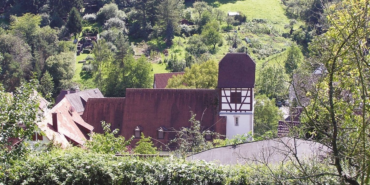 Ein Fachwerkhaus mit rotem Dach in einer gr&uuml;nen, l&auml;ndlichen Umgebung. Im Hintergrund sind G&auml;rten und B&auml;ume zu sehen., &copy; Stuttgart-Marketing GmbH