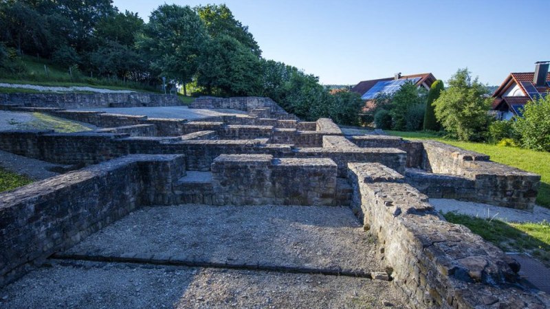 Ruinen der Villa Rustica in N&uuml;rtingen, umgeben von B&auml;umen und modernen H&auml;usern im Hintergrund., &copy; SMG, A. Mende