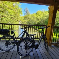 Zwei Fahrr&auml;der auf einer Holzbr&uuml;cke &uuml;ber einem Fluss, umgeben von &uuml;ppigem Gr&uuml;n und strahlend blauem Himmel., &copy; N&ouml;rdlicher Schwarzwald