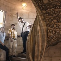 Gruppe von Menschen mit Helmen in einem historischen Gebäude, ein Mann zeigt nach oben. Verzierter Steinbogen im Hintergrund., © Stadtmarketing Göppingen