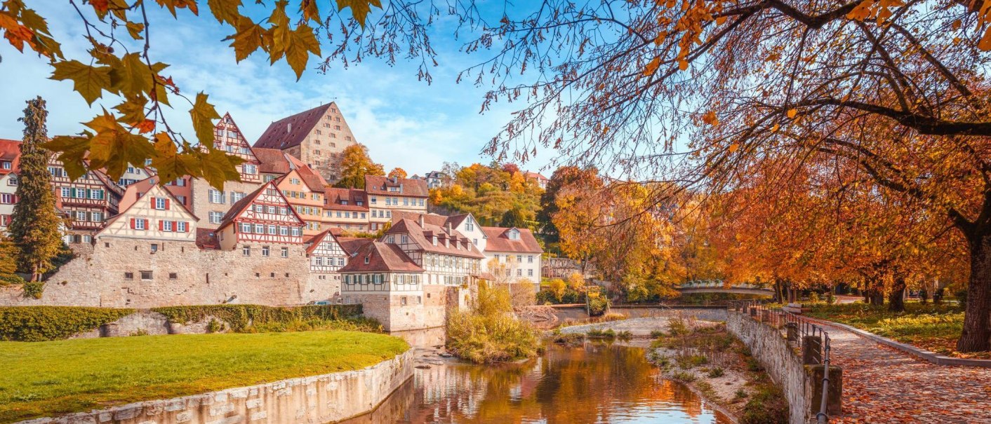 Herbstliche Szene in Schw&auml;bisch Hall mit Fachwerkh&auml;usern am Flussufer und buntem Laub an den B&auml;umen., &copy; Stadt Schw&auml;bisch Hall - Michael K&uuml;hneisen