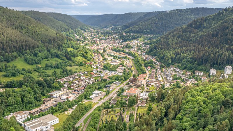 Luftaufnahme von Bad Wildbad im Schwarzwald, eingebettet in ein enges, bewaldetes Tal mit Stra&szlig;en, H&auml;usern und gr&uuml;nen H&auml;ngen., &copy; Lightworkart, Touristik Bad Wildbad GmbH