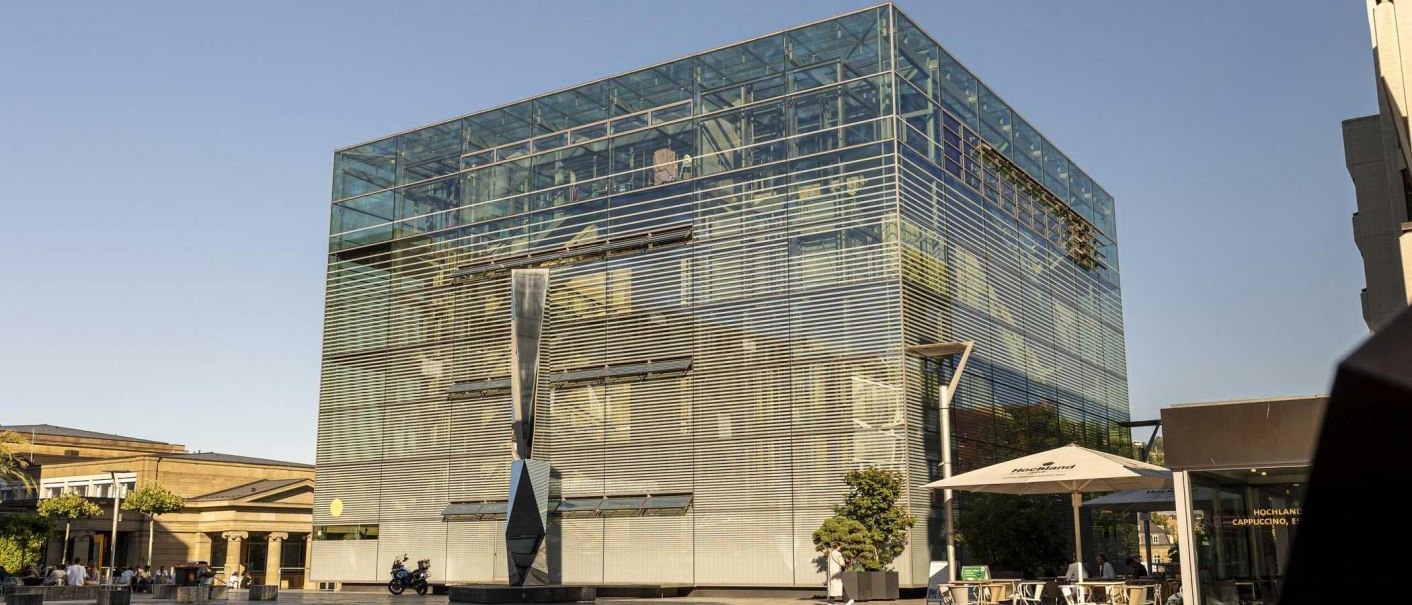 Das Kunstmuseum in Stuttgart mit seiner modernen Glasfassade und einer Skulptur davor, bei sonnigem Wetter am Kleinen Schlossplatz., © Stuttgart Marketing GmbH, Sarah Schmid Das Kunstmuseum in Stuttgart mit seiner modernen Glasfassade und einer Skulptur davor, bei sonnigem Wetter am Kleinen Schlossplatz., © Stuttgart Marketing GmbH, Sarah Schmid