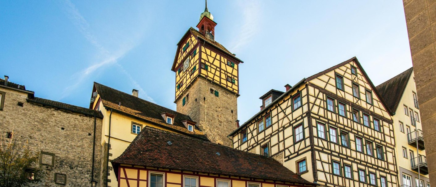 Fachwerkhäuser und ein historischer Turm in der Altstadt von Schwäbisch Hall unter blauem Himmel., © Stuttgart-Marketing GmbH, Sarah Schmid Fachwerkhäuser und ein historischer Turm in der Altstadt von Schwäbisch Hall unter blauem Himmel., © Stuttgart-Marketing GmbH, Sarah Schmid