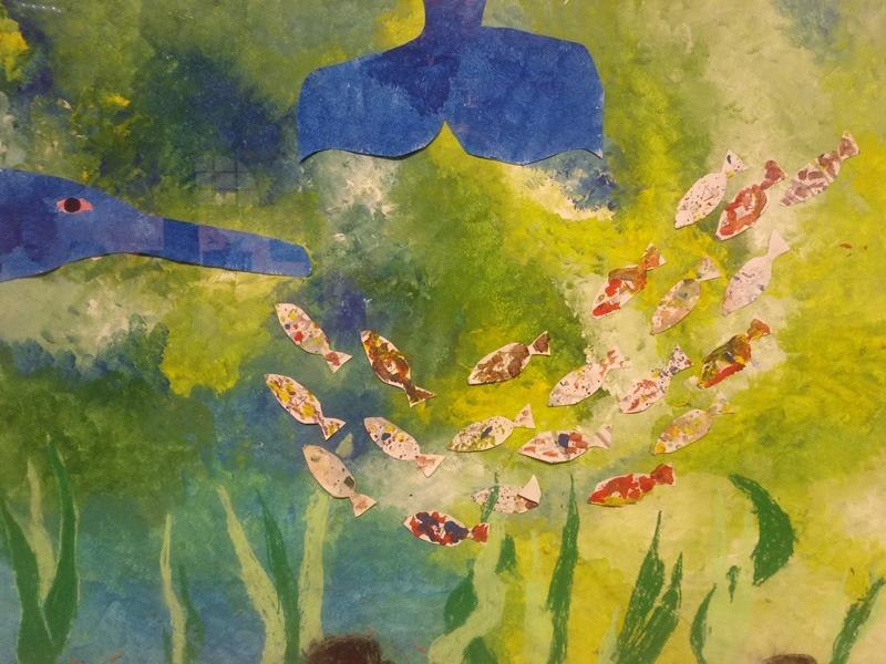 Ein buntes Unterwasserbild zeigt viele kleine Fische und eine große blaue Walflosse in einem grünen Hintergrund., © Kunstschule Labyrinth Ein buntes Unterwasserbild zeigt viele kleine Fische und eine große blaue Walflosse in einem grünen Hintergrund., © Kunstschule Labyrinth