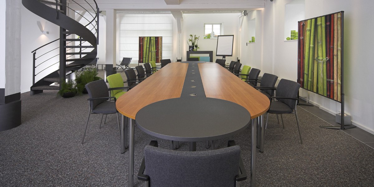 Moderner Konferenzraum mit ovalem Tisch, grauen und grünen Stühlen, Wendeltreppe und Bambusdekor., © Schlosshotel Monrepos Moderner Konferenzraum mit ovalem Tisch, grauen und grünen Stühlen, Wendeltreppe und Bambusdekor., © Schlosshotel Monrepos