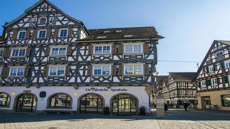 Fachwerkhäuser am Schorndorfer Marktplatz, darunter die Dr. Palm'sche Apotheke. Sonniges Wetter und blauer Himmel., © SMG, Sarah Schmid Fachwerkhäuser am Schorndorfer Marktplatz, darunter die Dr. Palm'sche Apotheke. Sonniges Wetter und blauer Himmel., © SMG, Sarah Schmid