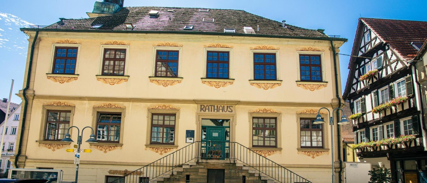 Das historische Rathaus von Vaihingen an der Enz mit seiner klassischen Fassade und einem angrenzenden Fachwerkhaus bei sonnigem Wetter., © Stuttgart-Marketing GmbH, Sarah Schmid
