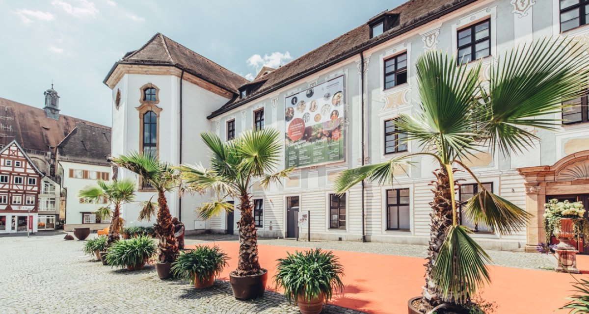 Das Museum im Prediger in Schwäbisch Gmünd, mit Palmen und einem roten Teppich im Vordergrund, bei sonnigem Wetter., © Tourismus Ostalb, Fotograf: Christian Frumolt Das Museum im Prediger in Schwäbisch Gmünd, mit Palmen und einem roten Teppich im Vordergrund, bei sonnigem Wetter., © Tourismus Ostalb, Fotograf: Christian Frumolt