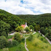 Luftaufnahme der Wallfahrtskirche Ave Maria Deggingen, eingebettet in eine grüne Waldlandschaft mit Hügeln im Hintergrund., © Landkreis Göppingen