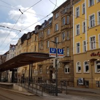 Stra&szlig;enbahnhaltestelle in einer st&auml;dtischen Stra&szlig;e, umgeben von alten Geb&auml;uden. Ein Restaurant namens Ha Long ist zu sehen., &copy; SMG