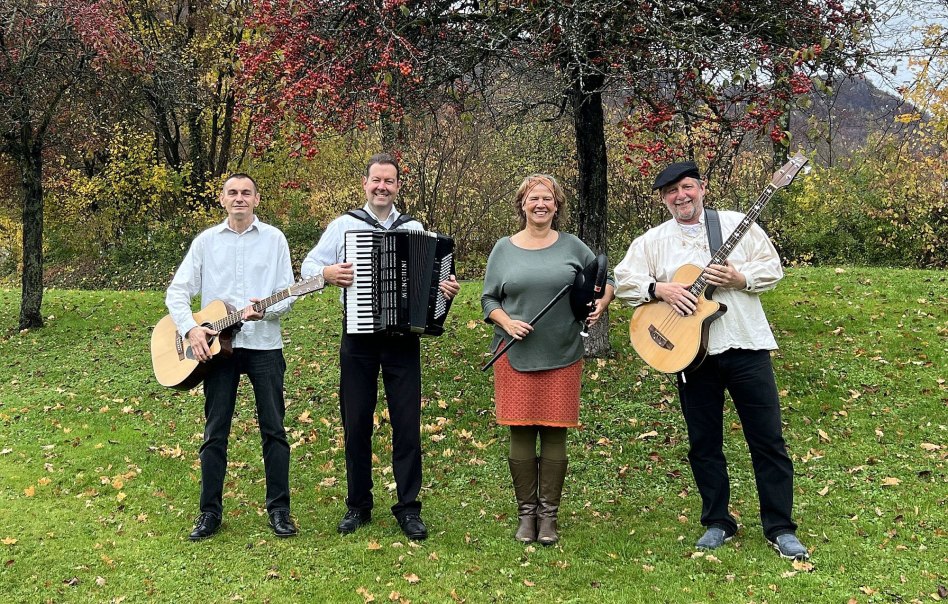 Vier Musiker posieren auf einer Wiese vor herbstlichen B&auml;umen. Zwei halten Gitarren, einer ein Akkordeon und eine Frau eine Fl&ouml;te. Sie l&auml;cheln in die Kamera., &copy; (c) The Craic
