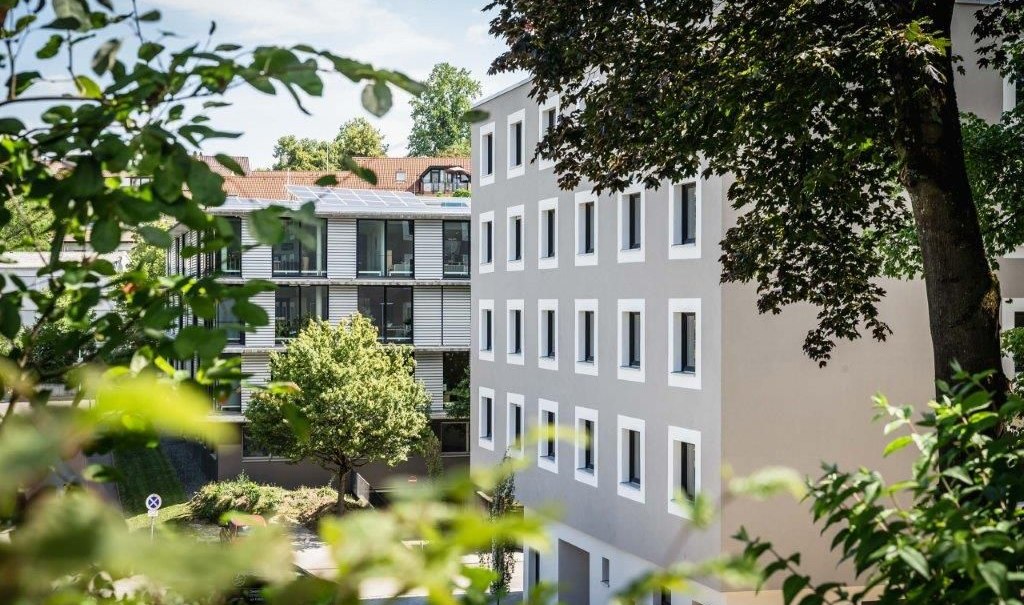 Zwei moderne Hotelgeb&auml;ude, umgeben von B&auml;umen und Gr&uuml;nfl&auml;chen, bei sonnigem Wetter., &copy; a2 HOTELS am Quadrium
