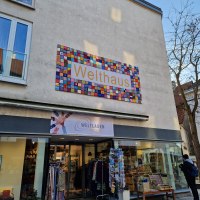 Das Welthaus in N&uuml;rtingen zeigt ein buntes Schild. Darunter befindet sich der Eingang zum Weltladen mit ausgestellten Waren., &copy; cStadtNuertingen