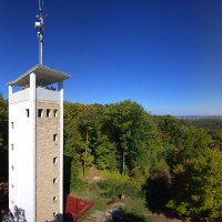 Der Uhlbergturm in Filderstadt erhebt sich über grüne Wälder, mit weitem Blick über die Landschaft unter klarem, blauem Himmel., © SMG Mende