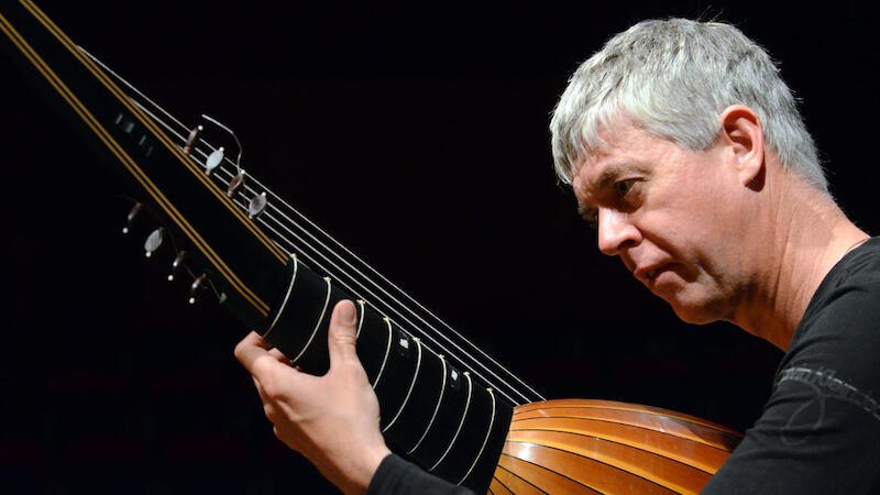 Ein Musiker spielt konzentriert auf einer Laute. Die Szene ist in warmem Licht gehalten, was eine intime Konzertatmosphäre schafft., © Jazzclub Schwäbisch Hall e.V. Ein Musiker spielt konzentriert auf einer Laute. Die Szene ist in warmem Licht gehalten, was eine intime Konzertatmosphäre schafft., © Jazzclub Schwäbisch Hall e.V.