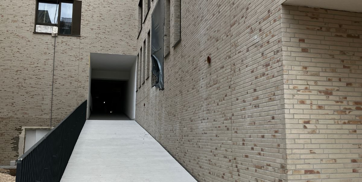 Eine wei&szlig;e Rampe f&uuml;hrt zu einem &uuml;berdachten Eingang zwischen hohen Backsteinw&auml;nden. Links ist ein schwarzes Gel&auml;nder., &copy; Stadt Esslingen am Neckar