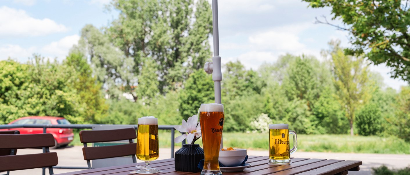 Ein Tisch auf einer Terrasse mit drei Biergläsern und einer Schale Snacks. Im Hintergrund sind Bäume und ein Auto zu sehen., © Plaza INN Stuttgart-Filderstadt Ein Tisch auf einer Terrasse mit drei Biergläsern und einer Schale Snacks. Im Hintergrund sind Bäume und ein Auto zu sehen., © Plaza INN Stuttgart-Filderstadt